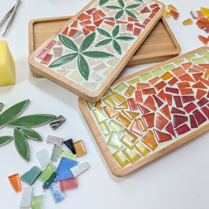 Mosaic art project with colorful tiles and tools on a white surface. Wendy Creative art class in Langford bc